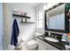 Bathroom features a black granite countertop vanity with a framed mirror and floating shelves at 941 Barbados Ave, Orlando, FL 32825