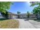 Charming single-story home featuring a two-car garage, a welcoming front yard, and solar panels on the roof at 941 Barbados Ave, Orlando, FL 32825