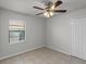 Well-lit bedroom with tile flooring, ceiling fan, window with blinds, and closet at 996 Big Oaks Dr, Oviedo, FL 32765