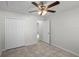 Simple bedroom with tile floors, ceiling fan, and closet doors for easy storage at 996 Big Oaks Dr, Oviedo, FL 32765