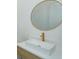 Close-up of bathroom sink with elegant gold hardware and a round mirror at 16825 Bolsena Dr, Montverde, FL 34756