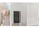 Bright foyer featuring a modern dark wood door, sleek tile flooring, and staircase with glass railings at 16825 Bolsena Dr, Montverde, FL 34756