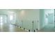 Upstairs hallway features light wood floors, frameless glass railing, and plenty of natural light at 16825 Bolsena Dr, Montverde, FL 34756