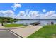Picturesque lakeside view with a wooden dock and boat launch ramp on a clear, sunny day at 16825 Bolsena Dr, Montverde, FL 34756