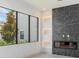 Modern living area with large window, electric fireplace and elegant marble accent wall at 16825 Bolsena Dr, Montverde, FL 34756