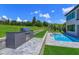 Backyard featuring an outdoor kitchen with a built-in grill and a refreshing swimming pool at 16825 Bolsena Dr, Montverde, FL 34756