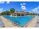 Large swimming pool area with lounge chairs and covered seating and grilling area at 16825 Bolsena Dr, Montverde, FL 34756