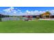 Community tennis courts with red umbrellas offering shaded seating and lush green grass surroundings at 16825 Bolsena Dr, Montverde, FL 34756