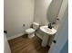Charming half bathroom featuring a pedestal sink and hardwood style floors at 2592 Pine Preserve Ct, St Cloud, FL 34771