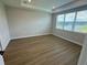 Bedroom with tray ceiling, wood-look floors, and large window with backyard view at 2592 Pine Preserve Ct, St Cloud, FL 34771