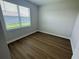Empty bedroom featuring wood-look floors, neutral paint, and backyard views at 2592 Pine Preserve Ct, St Cloud, FL 34771