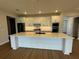 Gourmet kitchen with an island, white cabinets, modern appliances and decorative backsplash at 2592 Pine Preserve Ct, St Cloud, FL 34771