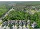 Panoramic aerial shot of a neighborhood with tree-lined streets, lush trees and a pond in the background at 8778 Peachtree Park Ct, Windermere, FL 34786
