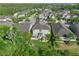 A high-angle shot of a home with a fenced backyard and landscaped patio, nestled among lush trees and other well-kept homes at 8778 Peachtree Park Ct, Windermere, FL 34786
