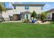 Expansive backyard with lush green lawn, a stone patio, and beautifully arranged garden beds around the perimeter at 8778 Peachtree Park Ct, Windermere, FL 34786