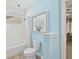 Bright bathroom featuring a tub with shower, white tile, and decorative ocean themed wall art at 8778 Peachtree Park Ct, Windermere, FL 34786