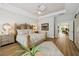 Bright bedroom with tray ceiling and wood floors, featuring an accent bed frame and barn door access to other rooms at 8778 Peachtree Park Ct, Windermere, FL 34786
