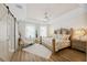 Bright bedroom with wood floors, featuring a decorative bed frame, tray ceiling, and lots of natural light at 8778 Peachtree Park Ct, Windermere, FL 34786