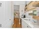 Charming butler pantry with wood floors, wine cooler, white cabinets, and countertops at 8778 Peachtree Park Ct, Windermere, FL 34786