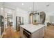 Bright kitchen island with white countertop, stainless appliances, and open layout to the stairs at 8778 Peachtree Park Ct, Windermere, FL 34786