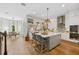 Bright kitchen with an island and seating, stainless appliances, white cabinets, and wood flooring at 8778 Peachtree Park Ct, Windermere, FL 34786