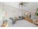 Open living room with a ceiling fan, hardwood floors, and decorative birds on the wall at 8778 Peachtree Park Ct, Windermere, FL 34786