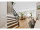 Open living room featuring wood stairs, dining area, and ample natural light from large windows at 8778 Peachtree Park Ct, Windermere, FL 34786