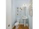 This powder room features wainscoting, hardwood floors, and beach-themed decorations for a unique and stylish touch at 8778 Peachtree Park Ct, Windermere, FL 34786