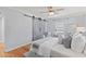 Bedroom featuring stylish barn door closet, ceiling fan, and wood floors at 919 Boardman St, Orlando, FL 32804