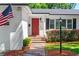 Inviting front entrance featuring a vibrant red door, brick steps, and neatly trimmed landscaping, enhancing curb appeal at 919 Boardman St, Orlando, FL 32804