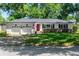 Charming home featuring a well-manicured lawn, inviting red door, and a two-car garage, exuding classic curb appeal at 919 Boardman St, Orlando, FL 32804