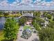 Aerial view of a community area with colorful buildings, a lake, green spaces, and manicured landscaping at 9421 Dugard Ct, Orlando, FL 32827