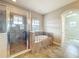 Bright bathroom featuring a glass shower enclosure, soaking tub, tiled flooring, and natural light at 9421 Dugard Ct, Orlando, FL 32827