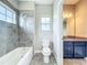 Well-lit bathroom with tiled bathtub and shower, complemented by a granite vanity at 9421 Dugard Ct, Orlando, FL 32827