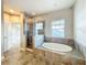 Bathroom featuring a soaking tub with tile surround and a glass shower with tile surround at 9421 Dugard Ct, Orlando, FL 32827