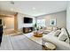 Modern living room with a large sectional sofa, media console, and hardwood-style flooring at 9421 Dugard Ct, Orlando, FL 32827