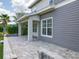 Side view of a home showcasing a covered patio with stone pavers and a neutral color scheme, blending indoor-outdoor living at 9421 Dugard Ct, Orlando, FL 32827
