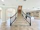 Elegant staircase with carpeted steps and black metal railings leading to the upper level of the home at 9421 Dugard Ct, Orlando, FL 32827