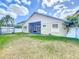 A spacious backyard with screened porch has lush green grass at 10356 Stone Glen Dr, Orlando, FL 32825