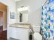 Cozy bathroom includes a granite vanity top, decorative mirror, and stylish shower curtain at 10356 Stone Glen Dr, Orlando, FL 32825