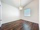Bright bedroom features hard floors, white walls, a modern light fixture, and natural light at 10356 Stone Glen Dr, Orlando, FL 32825