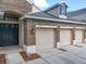 Close up of a brick home exterior featuring a three car garage and black front door at 10356 Stone Glen Dr, Orlando, FL 32825