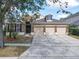 Charming brick home with three-car garage, manicured lawn, and mature trees at 10356 Stone Glen Dr, Orlando, FL 32825