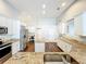 Open kitchen with granite countertops, stainless steel appliances, a central island, and white cabinets at 10356 Stone Glen Dr, Orlando, FL 32825