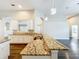 Spacious kitchen featuring granite countertops, white cabinets, a stainless steel sink and modern pendant lighting at 10356 Stone Glen Dr, Orlando, FL 32825