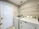 A full laundry room with washer, dryer, and hanging rack is located just inside the back door at 10356 Stone Glen Dr, Orlando, FL 32825