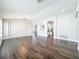 Spacious living room with dark hardwood floors, arched doorways, and a chandelier at 10356 Stone Glen Dr, Orlando, FL 32825