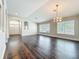 Expansive living room featuring dark wood floors and an arched doorway leading to the foyer at 10356 Stone Glen Dr, Orlando, FL 32825
