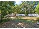 Large backyard featuring a white fence, mature trees, blue Adirondack chairs, and a charming swing at 108 S Glenwood Ave, Orlando, FL 32803