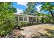 Back of the home featuring a porch, windowed sun room, and lush landscaping at 108 S Glenwood Ave, Orlando, FL 32803